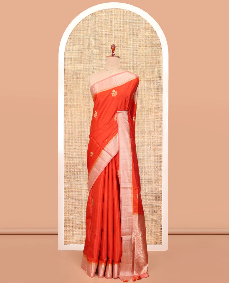 Orange Satin Silk Saree, Delicately Woven with Floral Buttas All Over Its Body, Complemented by a Contrast Border of Jaal Designs, Pallu of Jaal Designs in Zari, and Paired with a Contrast Blouse